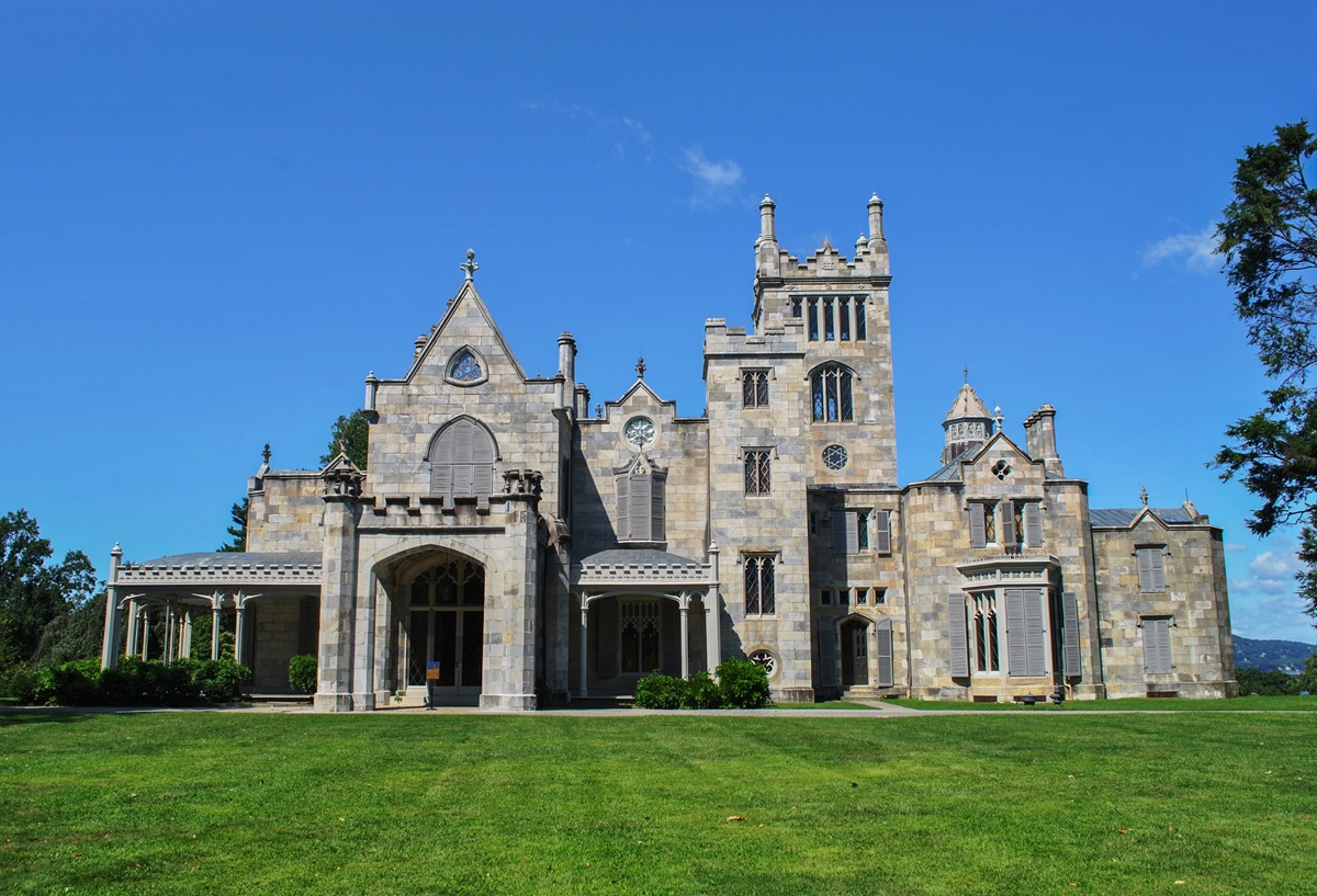 a stately gray castle on a green lawn
