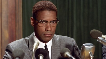 Denzel Washington as Malcolm X staring out over microphones at a press conference in 