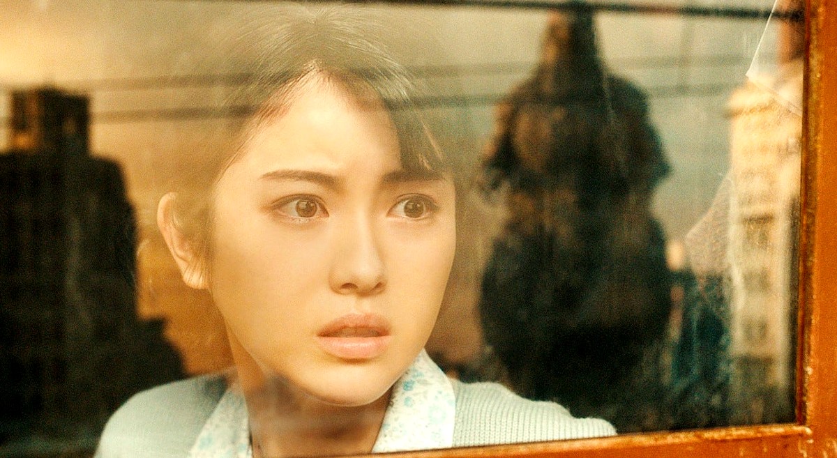 Minami Hamabe as Noriko Ōishi in Godzilla Minus One. There's a reflection of Godzilla in the window.