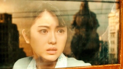 Minami Hamabe as Noriko Ōishi in Godzilla Minus One. There's a reflection of Godzilla in the window.