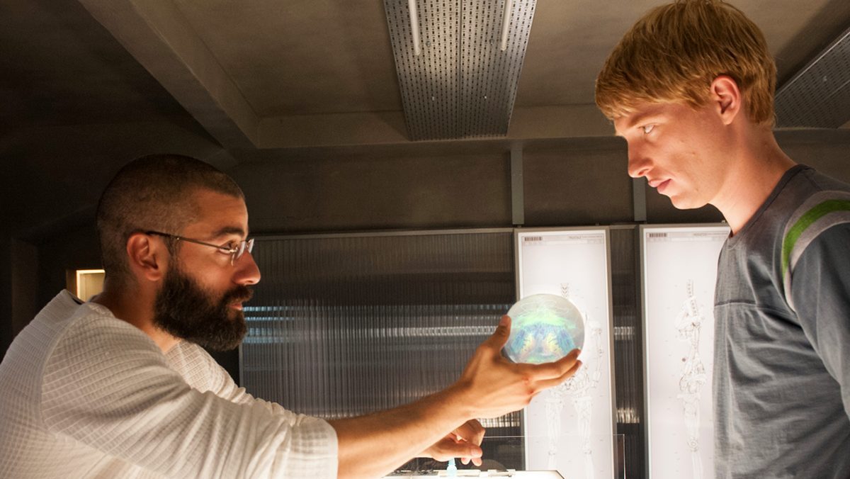 A man hands another man an artificial intelligence brain in 'Ex Machina.'