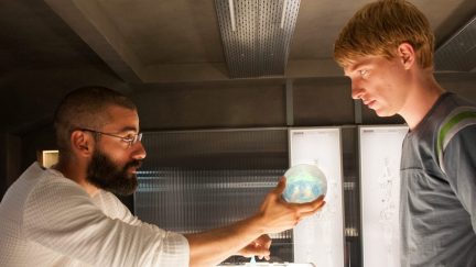 A man hands another man an artificial intelligence brain in 'Ex Machina.'