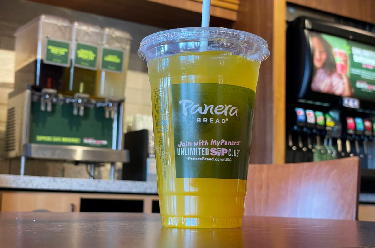 Panera Bread cup of lemonade in front of beverage dispenser. 