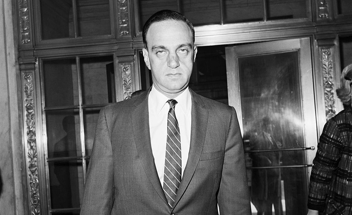 Roy Cohn outside of a courthouse in a black and white photo.