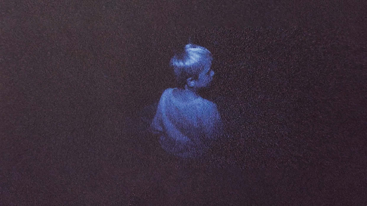 A small boy sits alone in the dark in 'Skinamarink'