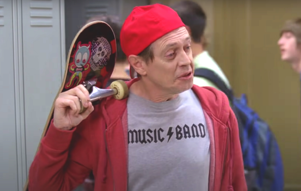 Steve Buscemi wears a backwards baseball capo and carris a skateboard in this image from '30 Rock'.
