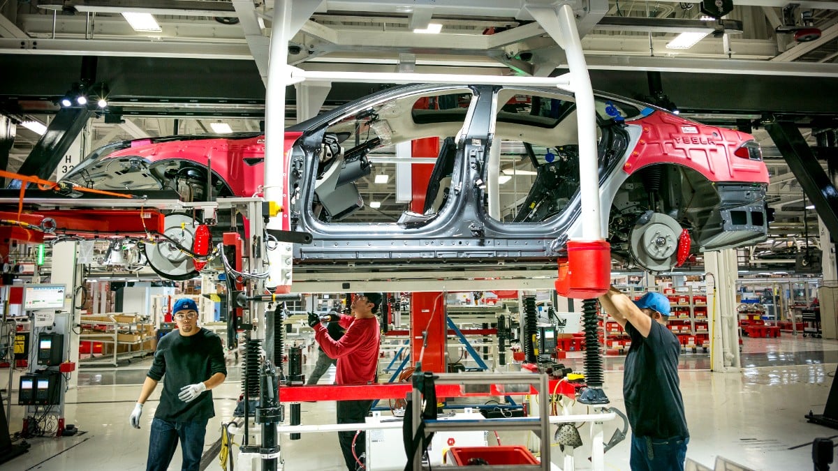 Workers assembling a car in Tesla's Fremont factory