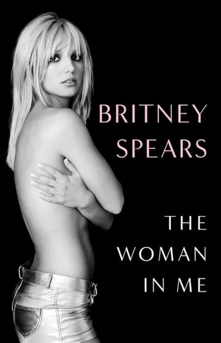 The Woman in Me by Britney Spears. On the book's cover is the author, topless but holding her chest with her hands.