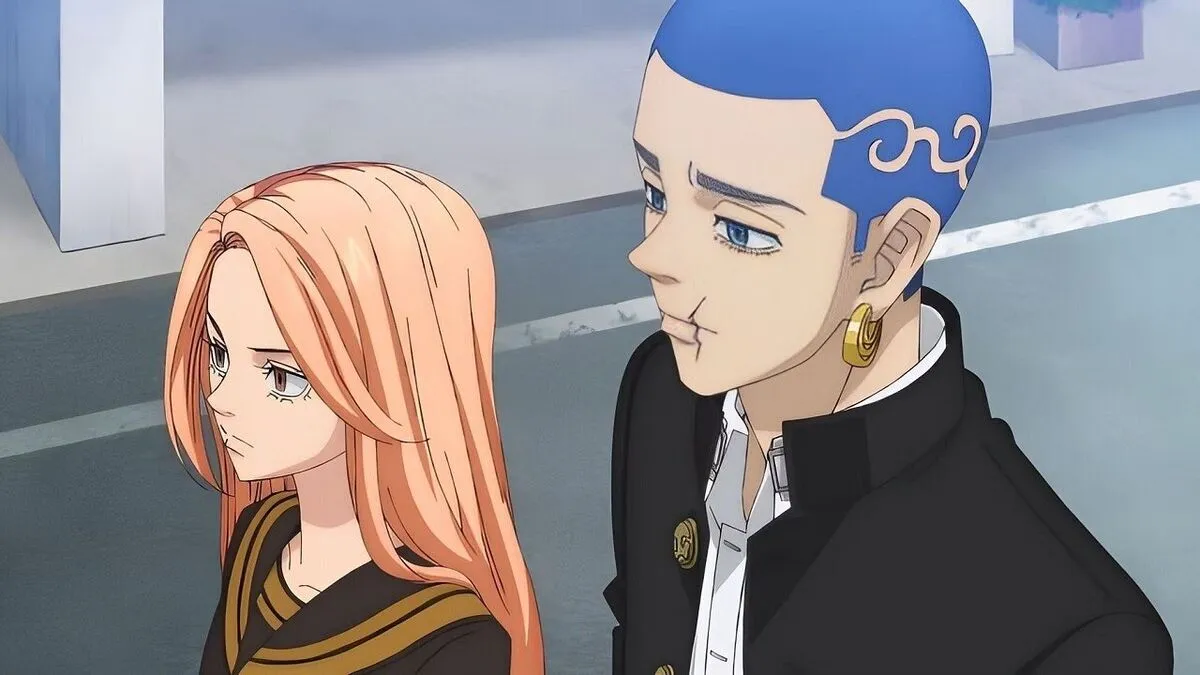 A scene from the anime series, 'Tokyo Revengers.' A teen girl with long peach hair and wearing a black dress with gold trim walks down a street beside a taller teen boy with cropped blue hair with a design shaved into the side of his head. He's wearing a black coat with gold buttons over a white buttondown and a gold earring. He has a scar on the left side of his mouth. 
