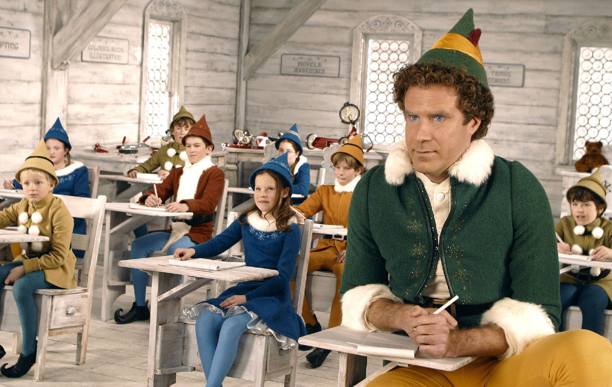 Buddy (Will Ferrell) sits among child-sized elves in 'Elf'