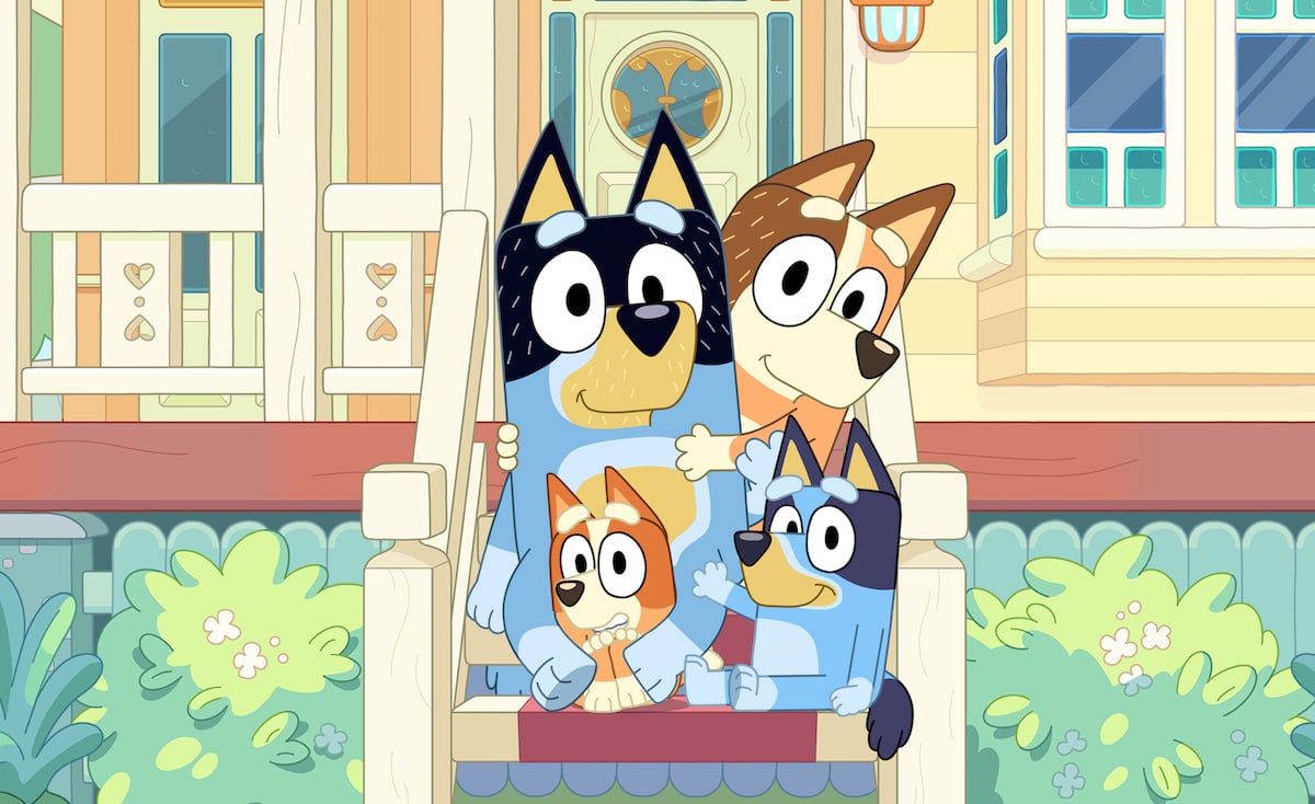 Bluey and her family pose on their porch, smiling.