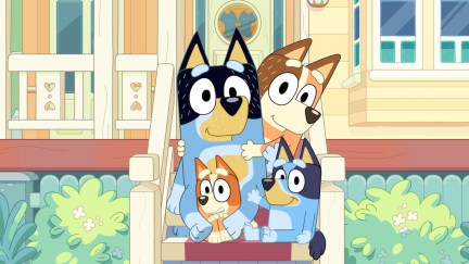 Bluey and her family pose on their porch, smiling.