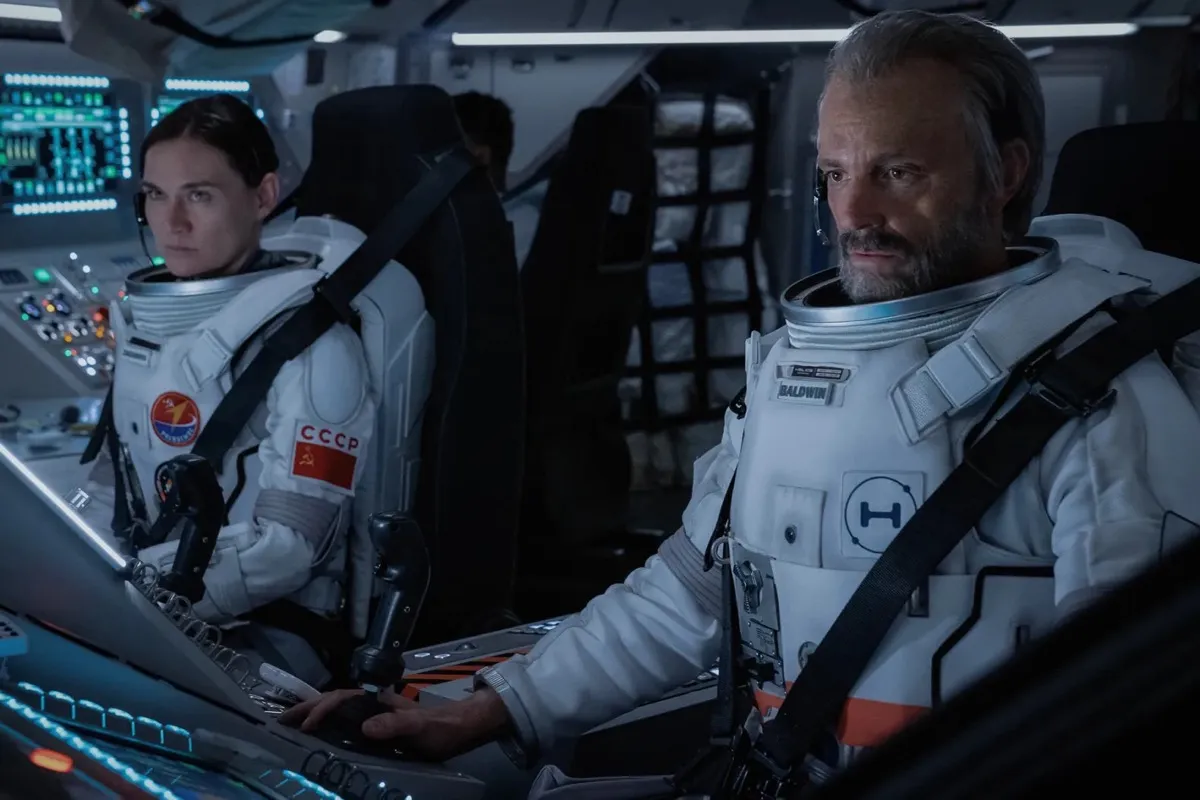 Two astronauts are strapped into a spaceship and studying something in "For All Mankind"