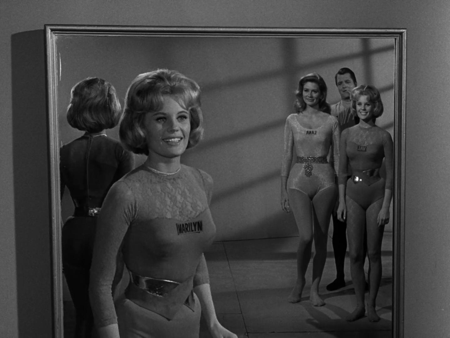 A group of young, fit, smiling people in leotards in a scene from The Twilight Zone.