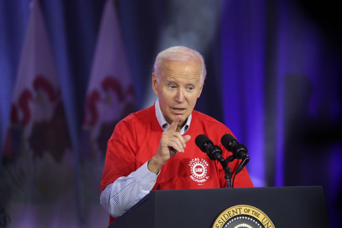 Joe Biden speaking at a podium, making a pointing hand gesture.