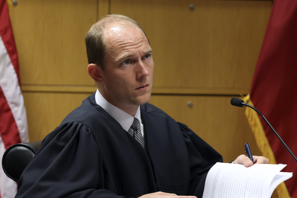Judge Scott MacAfee looks confused holding some documents.