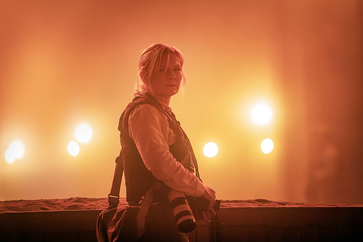 Kirsten Dunst standing in a red dust in Alex Garland's Civil War