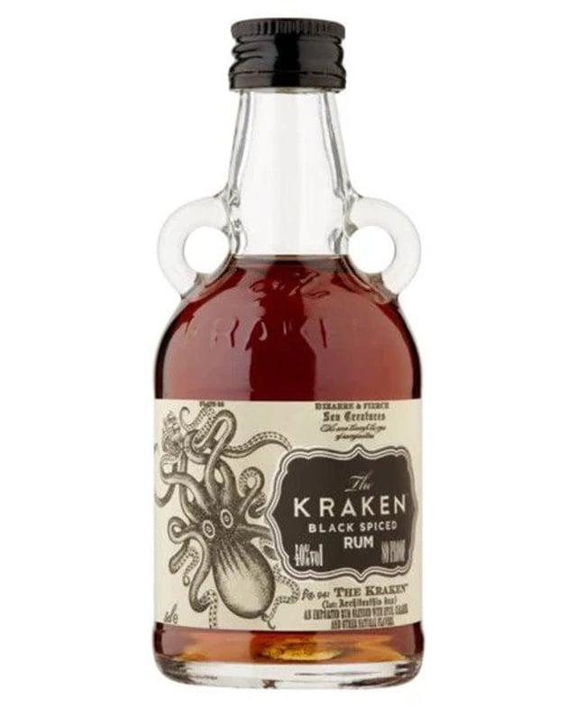 A mini bottle of Kraken rum, a two handled glass bottle with brown liquid inside and an aged paper style labour with a tentacled sea monster and black label on it.