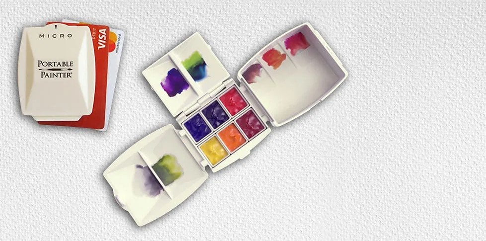 A credit card sized six colour watercolour paint palette with mixing pans.