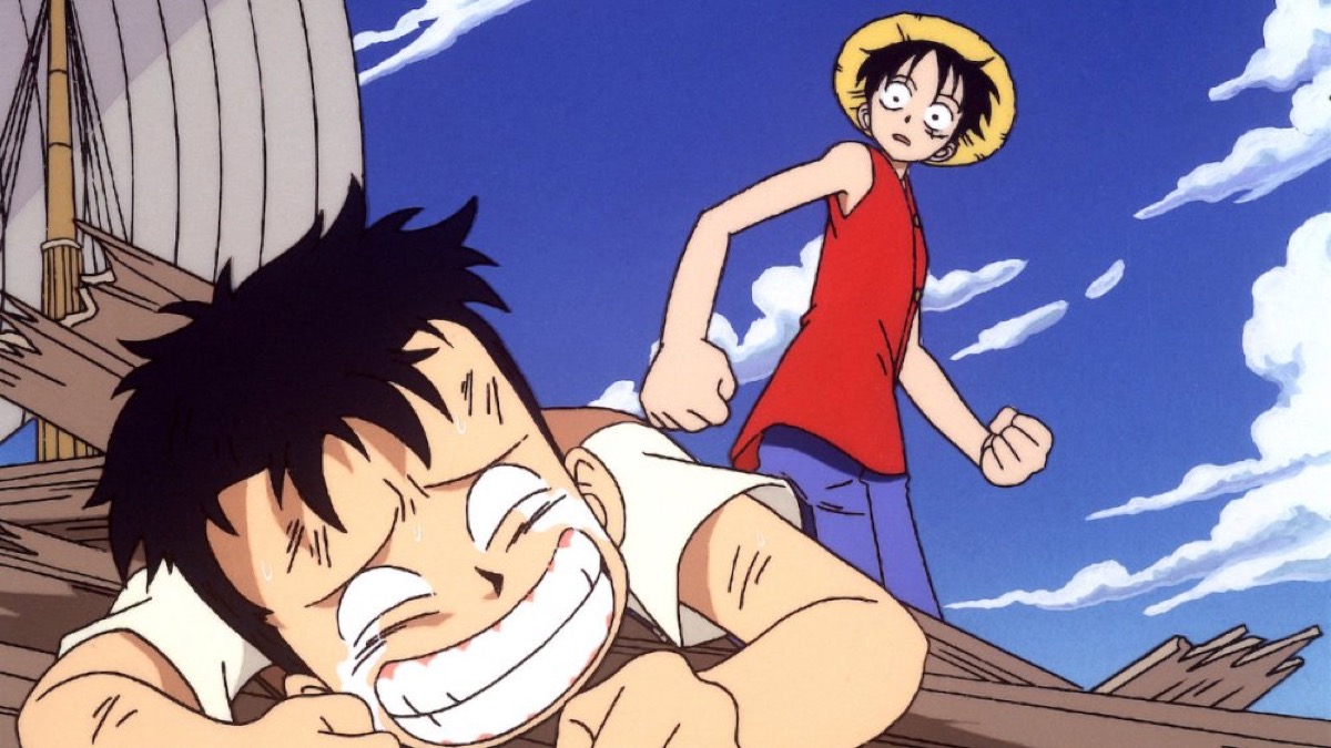 A boy in a straw hat stands over a crying child in "One Piece: The Movie"