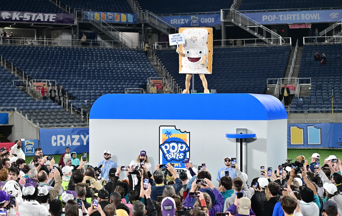 A Pop Tart mascot standing on a toaster at a football game