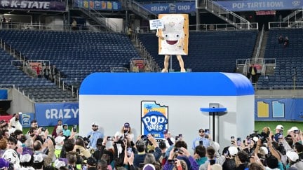 A Pop Tart mascot standing on a toaster at a football game