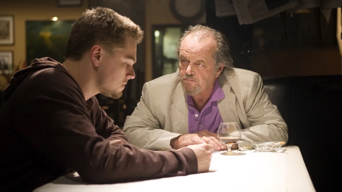 An Irish mob boss glares across a table at a young man in "The Departed" 