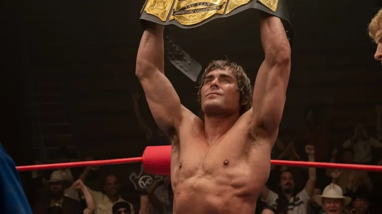 Zac Efron holding up the belt in the Iron Claw