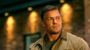 Jack Reacher (Alan Ritchson) stands outside 'Reacher.'