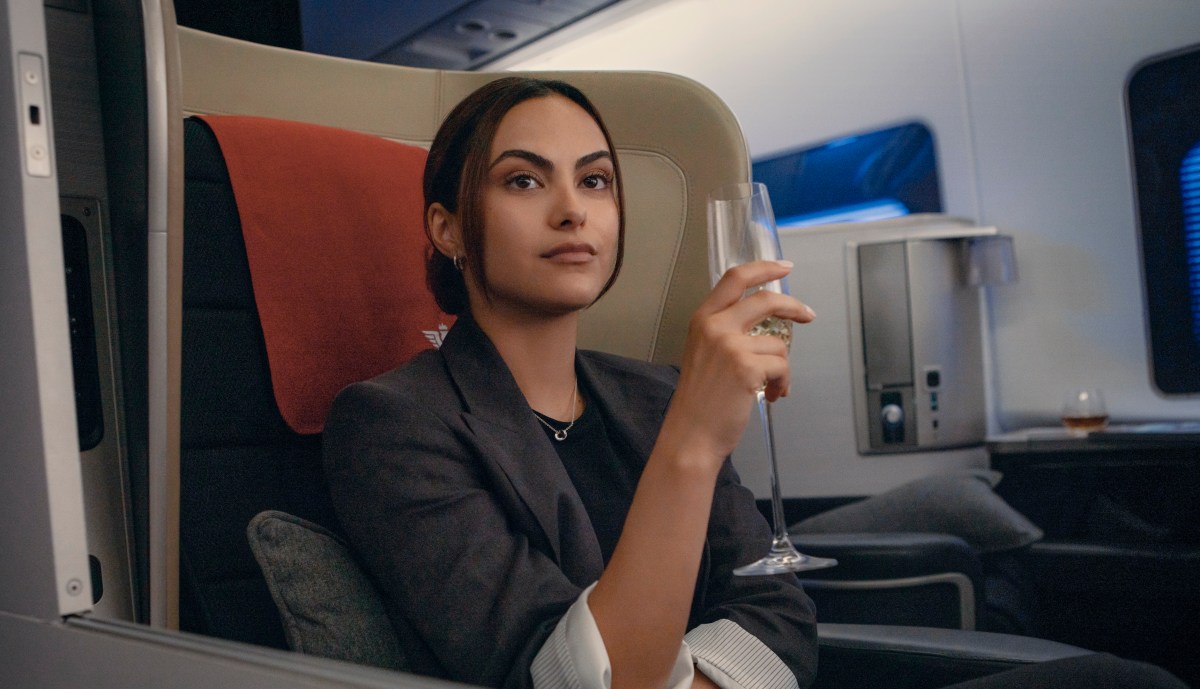 Camila Mendes stars as Ana Santos in UPGRADED sitting in an airplane seat