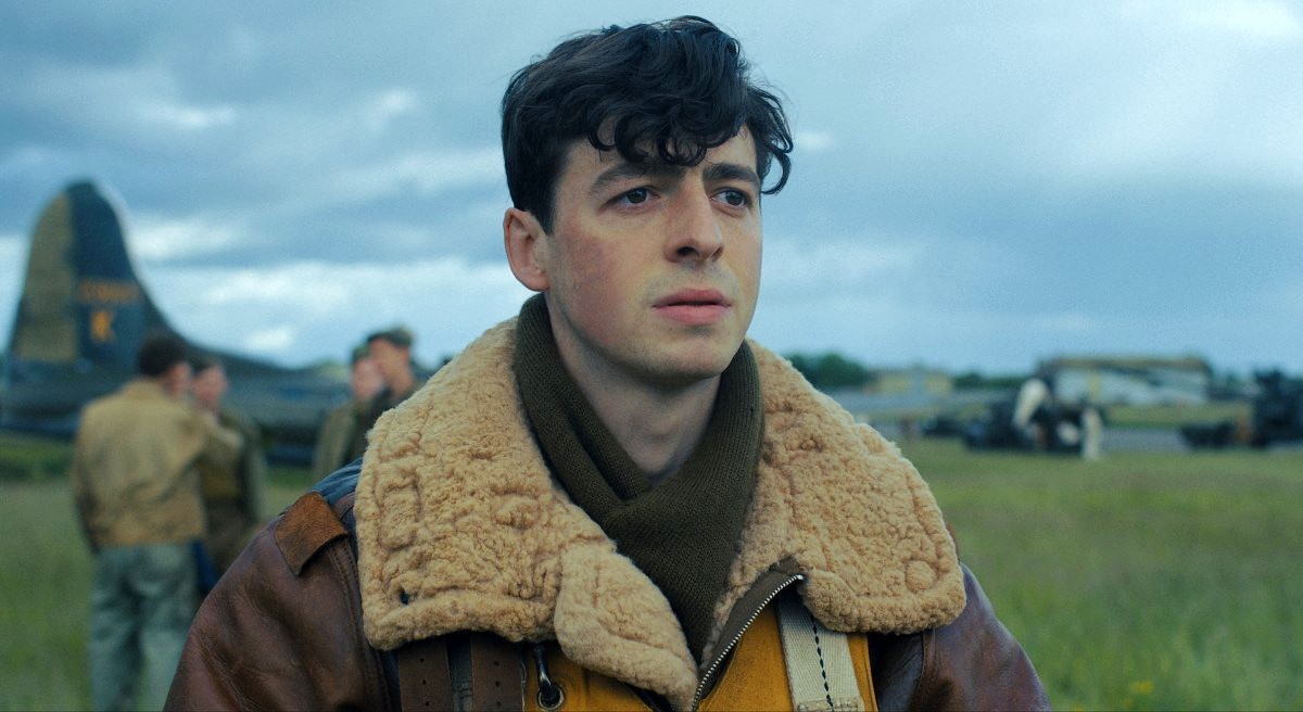 Harry Crosby (Anthony Boyle) stands in a field near planes in 'Masters of the Air.' 