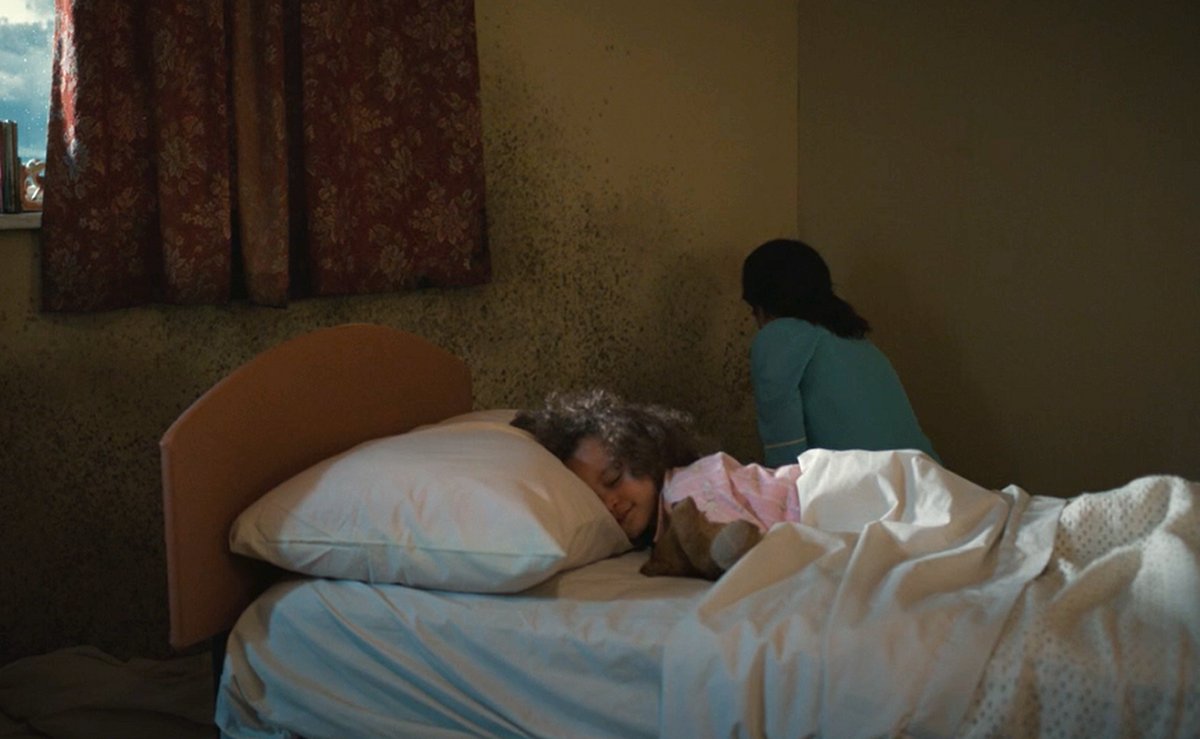 A mother and a sleeping child in a room filled with black mold in Call the Midwife (BBC)