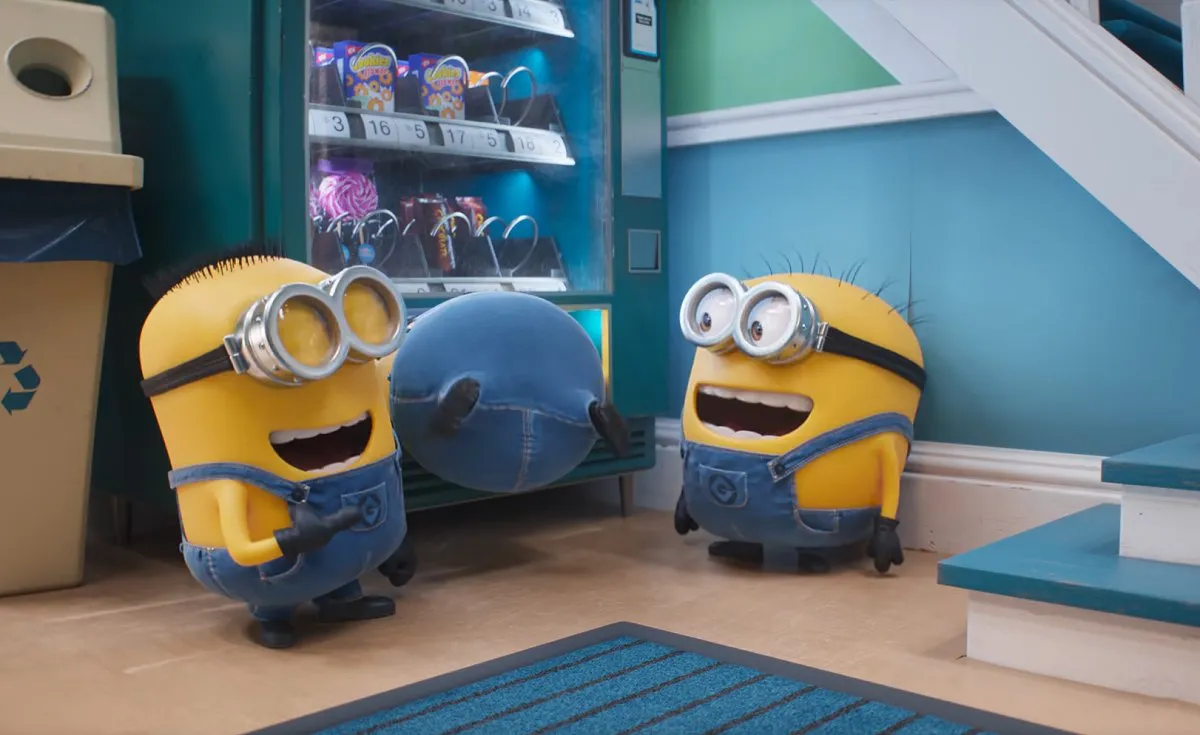 Two Minions laughing at a third Minion stuck in a vending machine