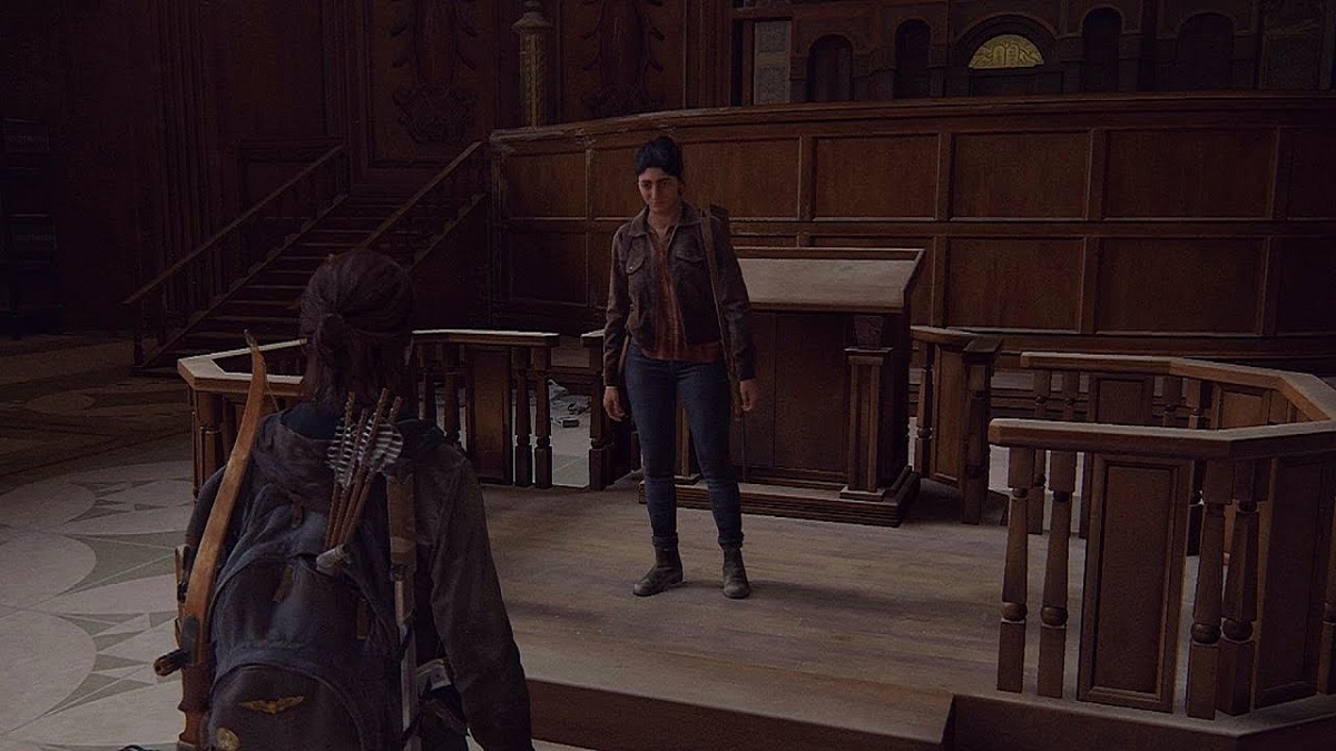 A scene from 'The Last of Us, Part II.' Dina stands on the bima in an abandoned Seattle synagogue facing Ellie, who's standing on the ground with her back to us. 