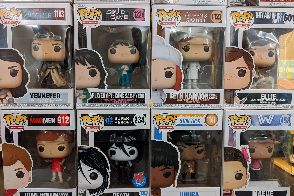 Image of eight Funko Pop figures in their boxes stacked four on four. Top from left to right: Yennifer (The Witcher), Player 067 (Squid Game), Beth Harmon (The Queen's Gambit), Ellie (The Last of Us Part II). Bottom from left to right: Joan Holloway (Mad Men), Death (The Sandman), Uhura (Star Trek), Maeve (Westworld).