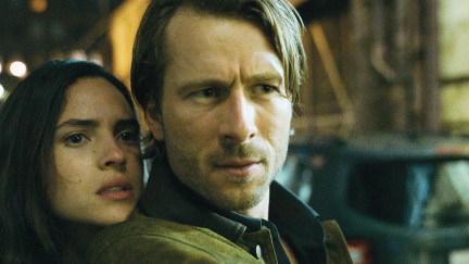Glen Powell and Adria Arjona standing very close together in 'Hit Man'