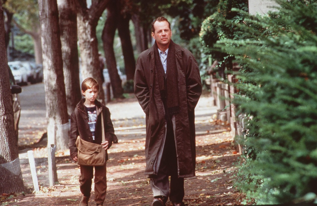 A man and a young boy walking together on a sidewalk