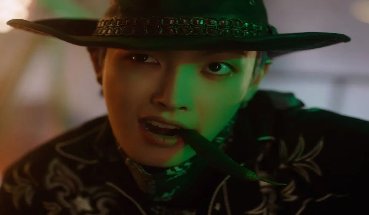 Hongjoong from ATEEZ wears a hat and bites his finger.