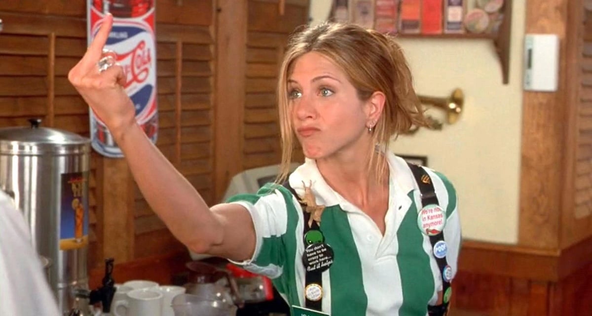 A white woman (Jennifer Aniston) flips the bird in a scene from Office Space.