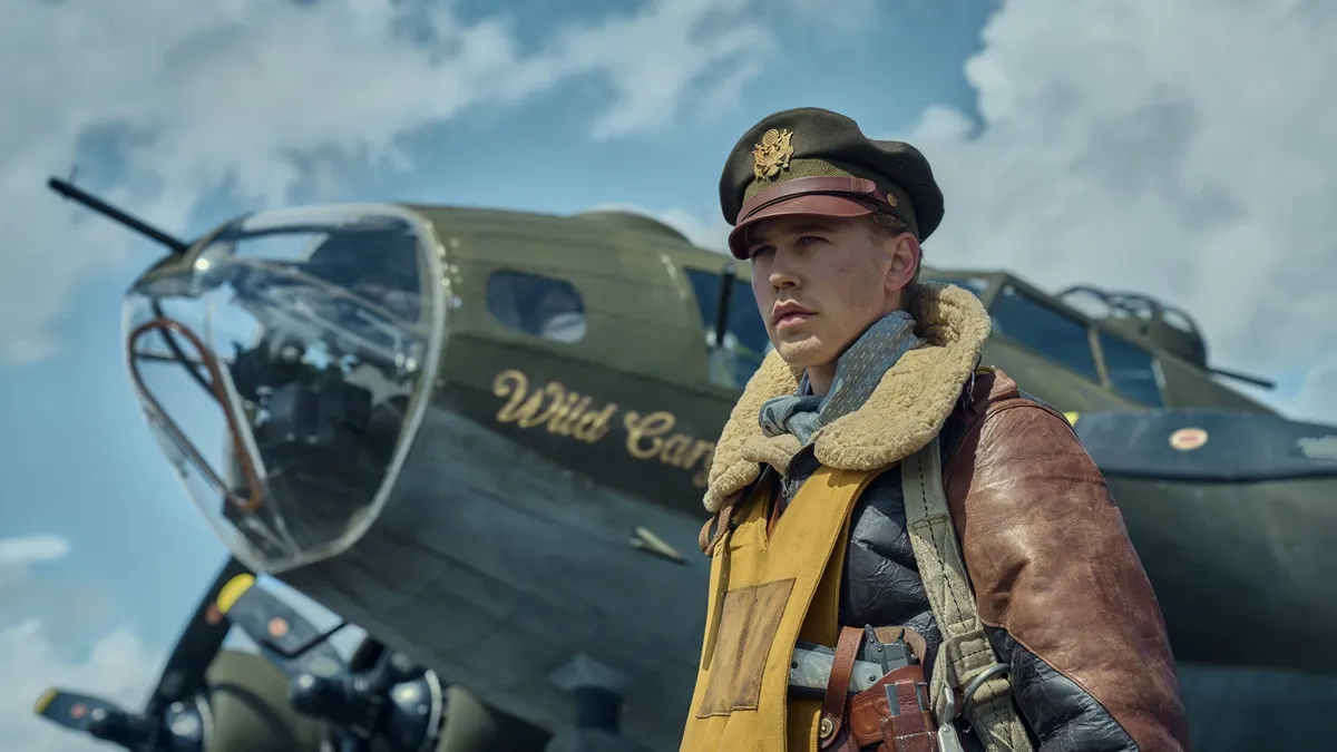 Austin Butler wearing pilot uniform and standing in front of plane as Major Gale Cleven in "Masters of The Air"