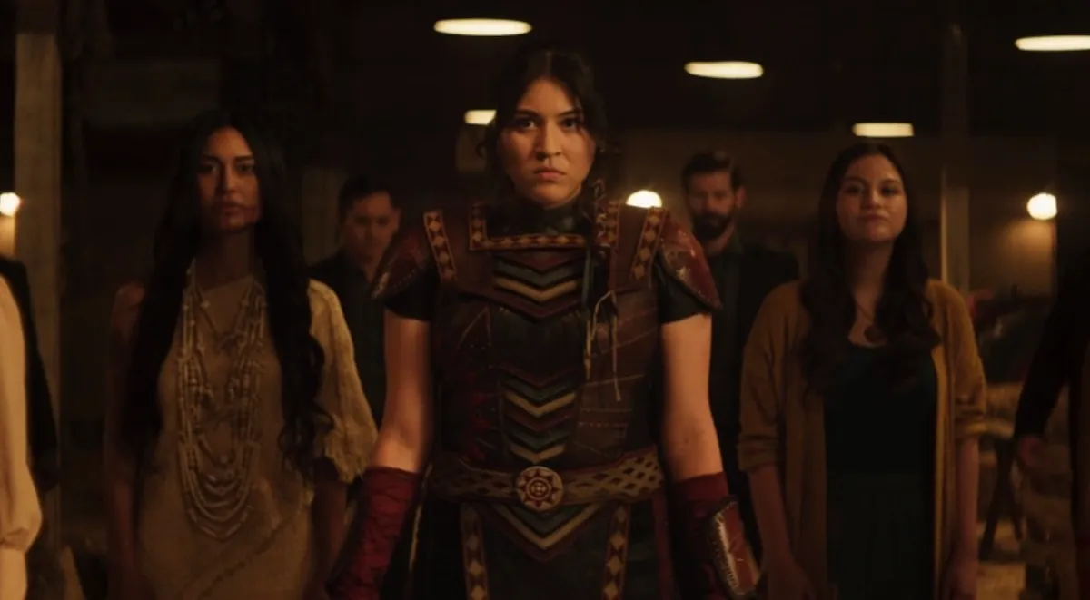 Maya, dressed in the outfit Chula made her, stands with her ancestors flanking her.