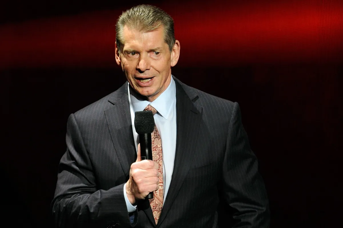 Vince McMahon standing with a microphone