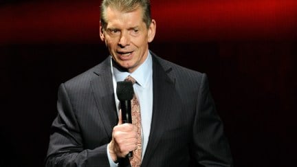 Vince McMahon standing with a microphone