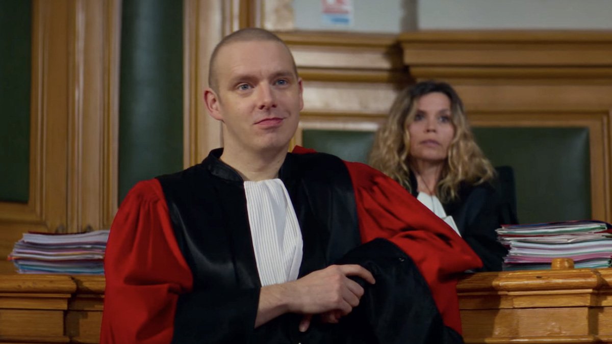 Antoine Reinartz looking smug leaning on a bench in court in Anatomy of a Fall