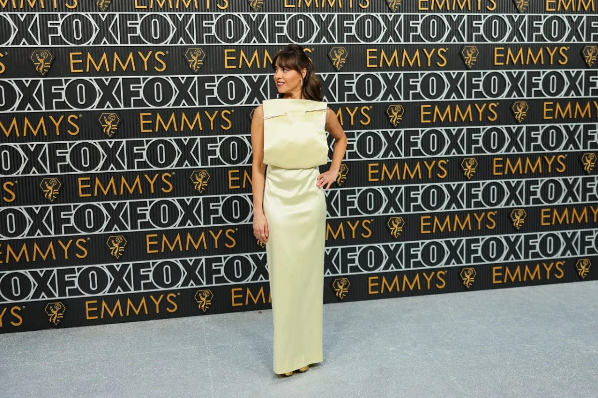 Aubrey Plaza wears a yellow dress with a square front and a giant pin through the top at the 2023 Emmy Awards.