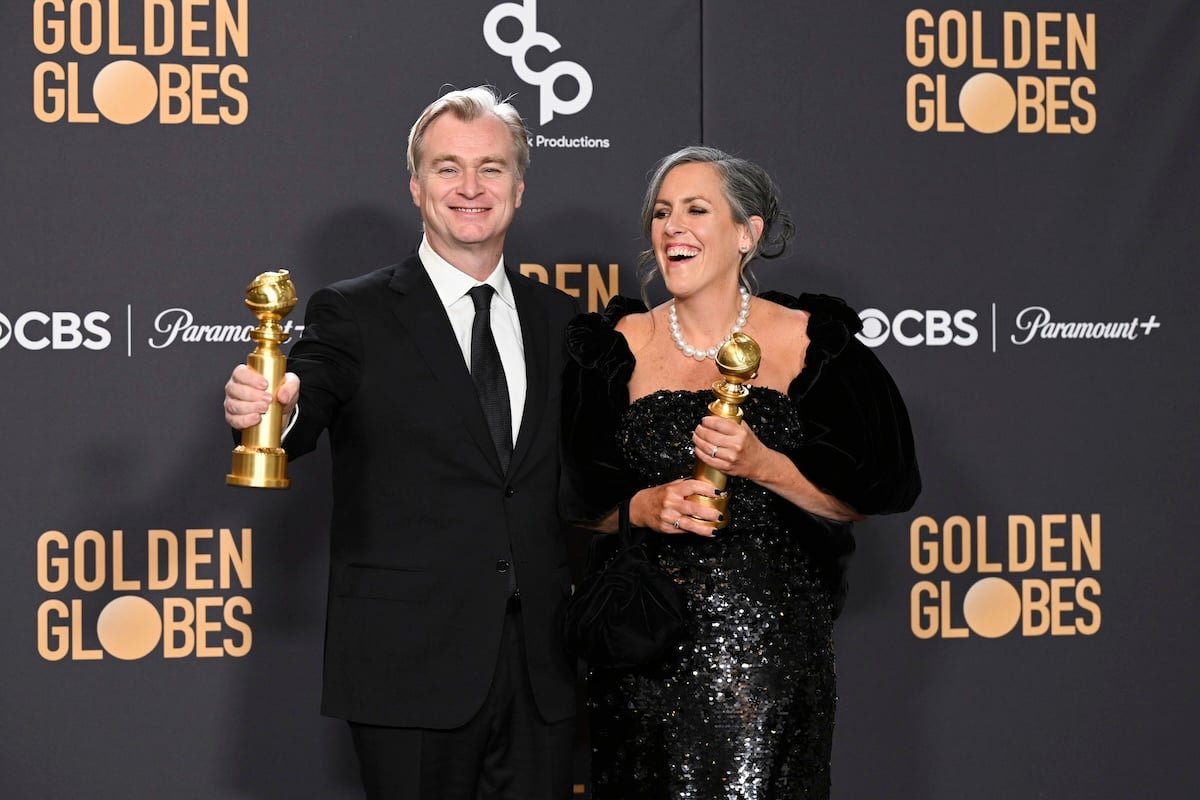Christopher Nolan and Emma Thomas standing with their Golden Globes