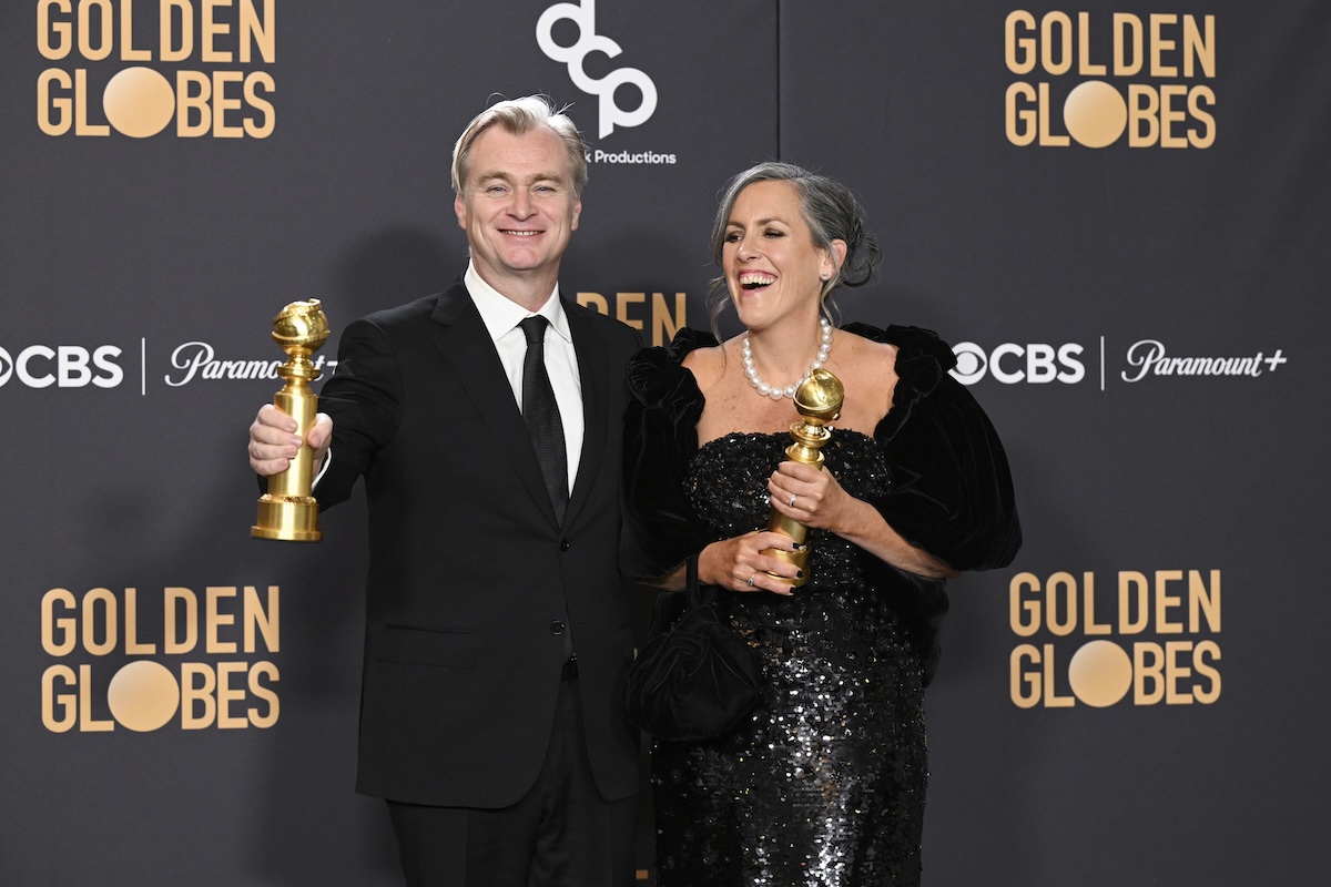 Christopher Nolan and Emma Thomas standing with their Golden Globes