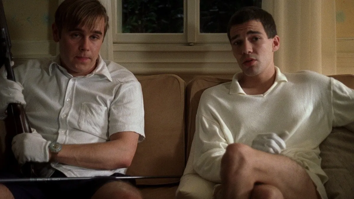 Two young men sit on a sofa in the film "Funny Games" 