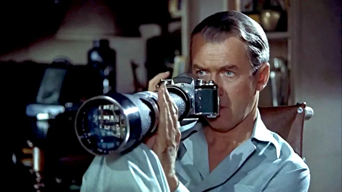 Jimmy Stewart holds up a camera in Rear Window.