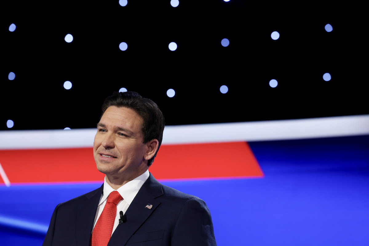 Ron DeSantis smiles awkwardly on the debate stage.
